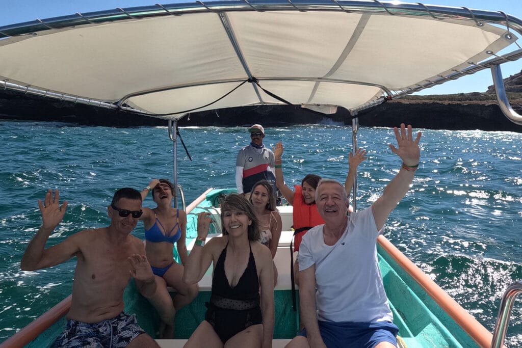 Familia saludando felizmente desde la lancha en su tour privado en Punta de Mita.